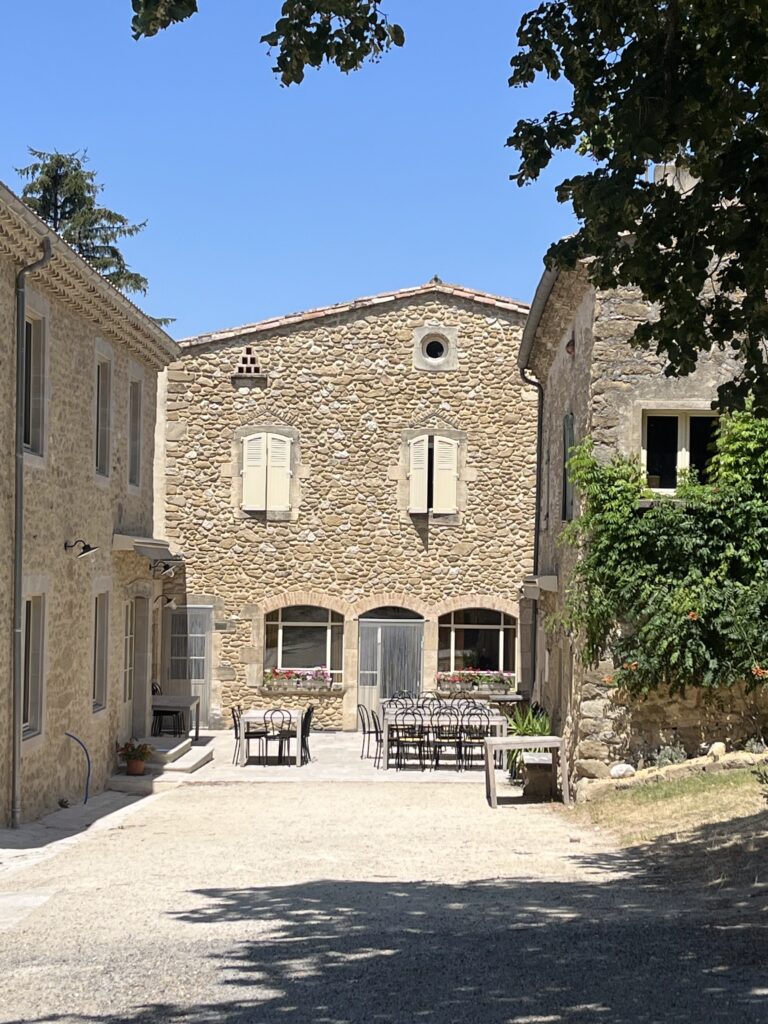 La cour en pierre de La Croisée et ses tables en terrasse